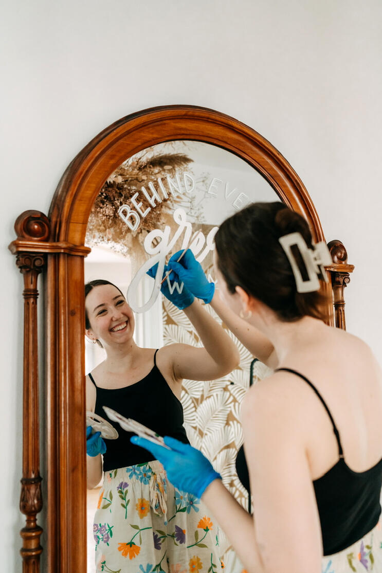 Das Bild zeigt Antonia Hafner beim Bemalen eines großen Spiegels.